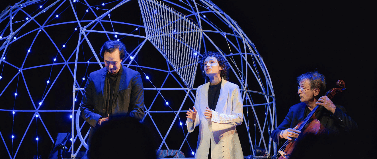 Artistes sur scène devant le dôme lumineux de L’Odyssée musicale du cerveau.